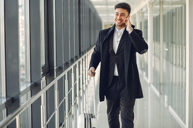 Businessman walking through an airport terminal while talking on his phone